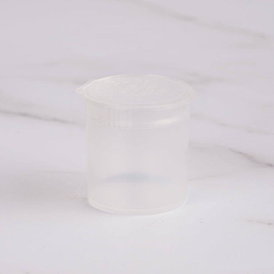 Small Pop Tops Containers 6 Dram, frosted clear, on a marble surface